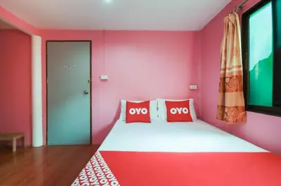 a red room with a bed with red pillows at OYO 1163 Eden Hostel in Phuket Town