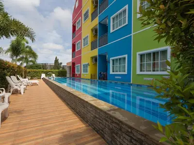 a swimming pool in front of a building at Holland Resort Phuket in Ban Phlu Yai