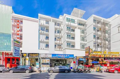 a large white building with cars parked in front of it at OYO 472 Tang Cheng Holiday Hotel in Patong Beach