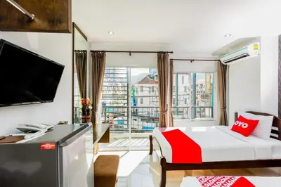 a hotel room with a bed and a large window at OYO 472 Tang Cheng Holiday Hotel in Patong Beach