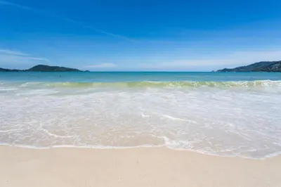 a beach with the ocean and the sand at OYO 472 Tang Cheng Holiday Hotel in Patong Beach