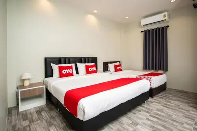 a bedroom with two beds with red and white pillows at OYO 259 Baan Napatr in Ban Thalat Choeng Thale