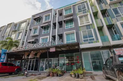 a building with a black dragon inn on a street at OYO 1162 Chalong Home Place in Ban Klang