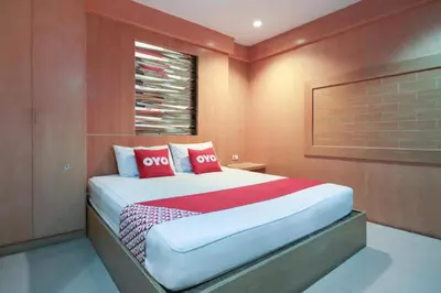 a bedroom with a bed with red and white pillows at OYO 1172 Goodnight Resort in Phuket Town