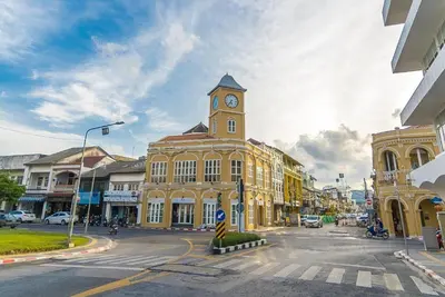 a large yellow building with a clock tower on a street at OYO 1172 Goodnight Resort in Phuket Town