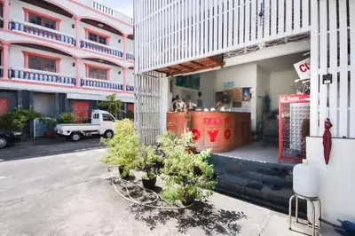 a building with some plants in front of it at OYO 1172 Goodnight Resort in Phuket Town