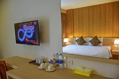 a hotel room with a bed and a tv on the wall at Ocean and Ole Patong in Patong Beach