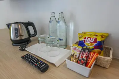 a table with two bottles of water and a remote control at Ocean and Ole Patong in Patong Beach
