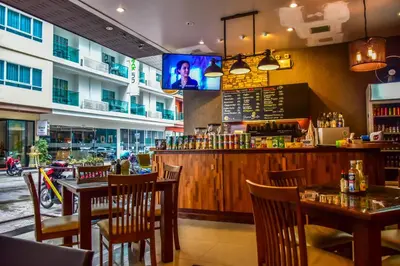 a restaurant with tables and chairs and a bar at Ocean and Ole Patong in Patong Beach