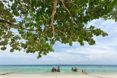 a view of the beach with two boats in the water at Phuttachot Resort in Phi Phi Don