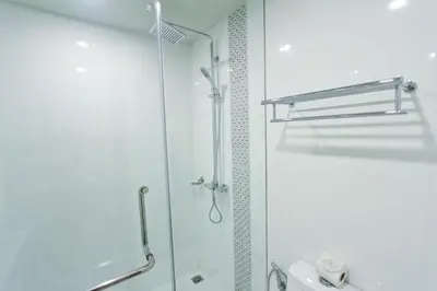 a bathroom with a shower with a glass door at Elegancy Sansabai Hotel in Patong Beach
