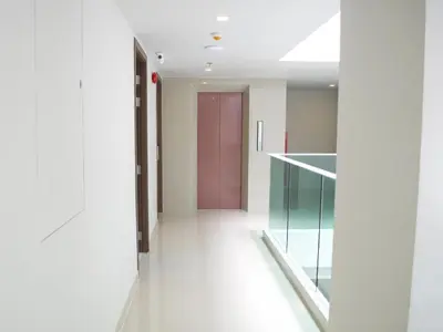 a hallway with a pink door in a building at Elegancy Sansabai Hotel in Patong Beach