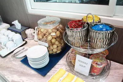 a counter topped with plates and jars of food at Elegancy Sansabai Hotel in Patong Beach
