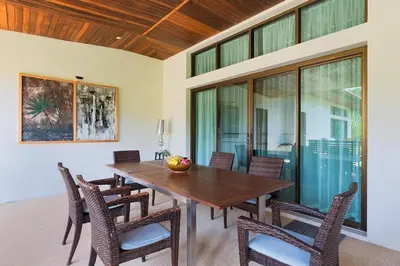 a dining room with a wooden table and chairs at Villa Oxavia in Rawai Beach