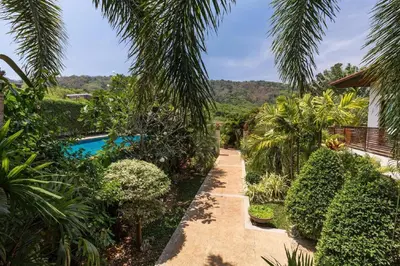 a garden with a pathway and a swimming pool at Villa Oxavia in Rawai Beach