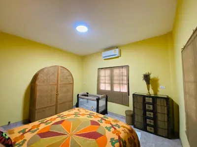 a bedroom with a large bed and a window at Lakshmi beach house in Phuket Town
