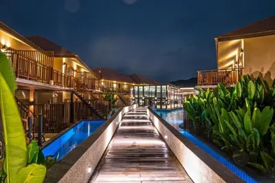 a hotel swimming pool at night with buildings at Blue Koh Yao Yai Resort and Villa in Ko Yao Yai