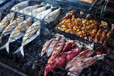 a bunch of different types of meat on a grill at Blue Koh Yao Yai Resort and Villa in Ko Yao Yai