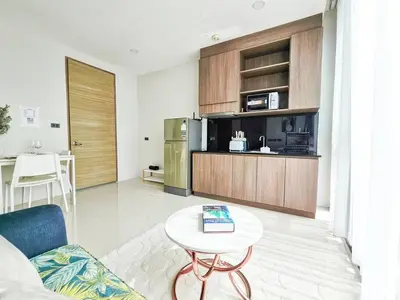 a living room with a table and a kitchen at Seaview room nice sunset Patong in Patong Beach