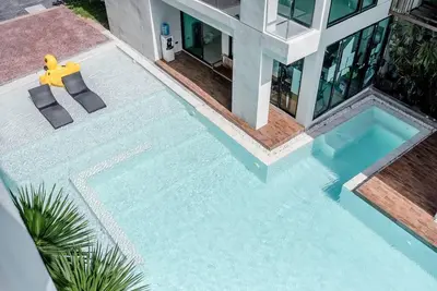 a swimming pool with two chairs and a house at Seaview room nice sunset Patong in Patong Beach