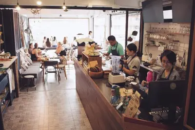 a group of people sitting at a counter in a restaurant at Mini Boxtel Aonang Hostel in Ao Nang Beach