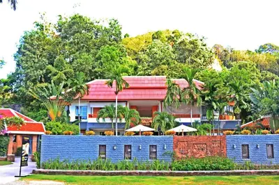 a blue building with a red roof and trees at Royal Lee Resort and Spa in Ban Bo Han