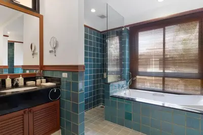 a blue tiled bathroom with a tub and a sink at Laguna Fairway View Villa in Bang Tao Beach