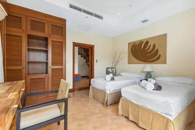 a hotel room with two beds and a table and chairs at Laguna Fairway View Villa in Bang Tao Beach