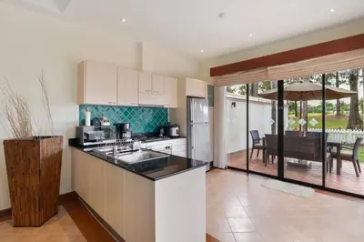 a kitchen with a counter top and a dining room at Laguna Fairway View Villa in Bang Tao Beach