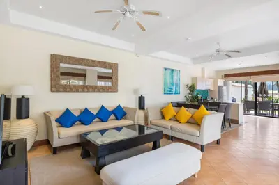 a living room with blue and yellow pillows at Laguna Fairway View Villa in Bang Tao Beach