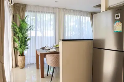 a kitchen with a refrigerator and a table in it at Super Friendly TH Laguna Park in Phuket Town
