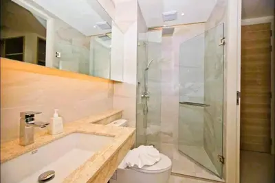 a bathroom with a shower and a sink and a toilet at Stunning sea view apartment with pool in Ao Nang Beach