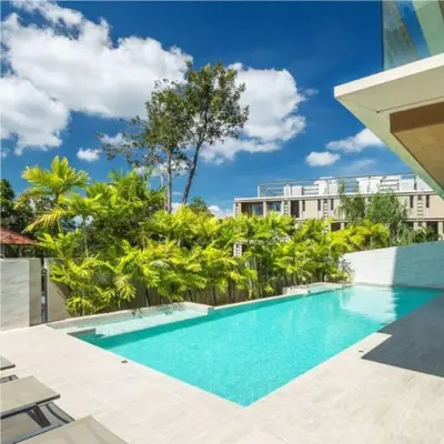 a swimming pool with trees and a building at Stunning sea view apartment with pool in Ao Nang Beach