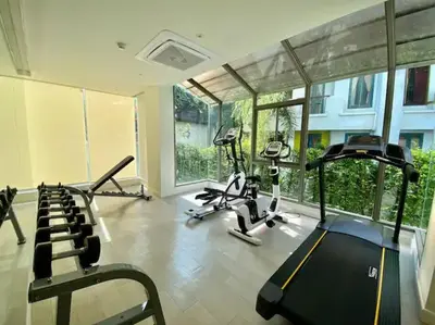a gym with treadmills and exercise bikes in a room at Stunning sea view apartment with pool in Ao Nang Beach
