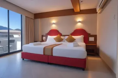 a bedroom with a large bed and a large window at Hack Patong Beach Hotel in Patong Beach