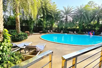 a swimming pool with lounge chairs and a resort at Новая квартира с выходом к бассейну in Mai Khao Beach