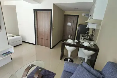 a living room with a table and chairs in a room at Новая квартира с выходом к бассейну in Mai Khao Beach
