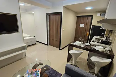 a living room with a table and a room with a bed at Новая квартира с выходом к бассейну in Mai Khao Beach
