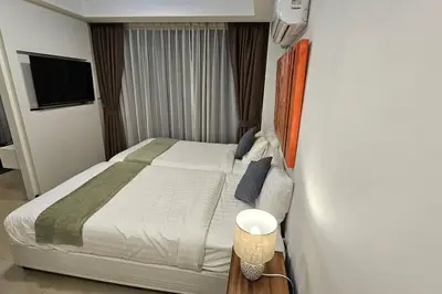a bedroom with a bed and a television in it at Новая квартира с выходом к бассейну in Mai Khao Beach
