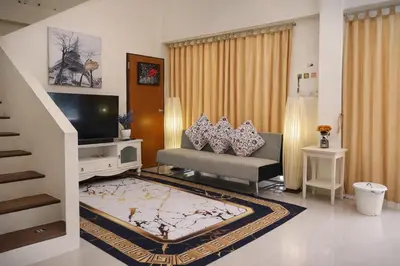 a living room with a couch and a television at Grand Chalong Family House in Chalong