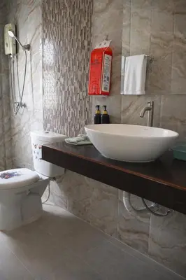 a bathroom with a white sink and a toilet at Grand Chalong Family House in Chalong