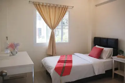 a bedroom with a bed and a window at Grand Chalong Family House in Chalong
