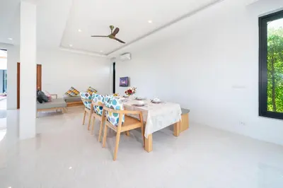 a dining room with a table and chairs at Garden pool villa V110 in Kata Beach