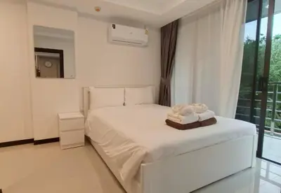 a white bedroom with a bed and a window at Rawai Beach Condo by Holy Cow in Nai Harn Beach