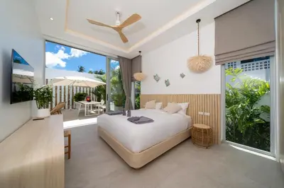 a bedroom with a large bed and a balcony at Tropical Brand New 4BR Pool Villa Mina, just 5 min Drive from Naiharn in Rawai Beach