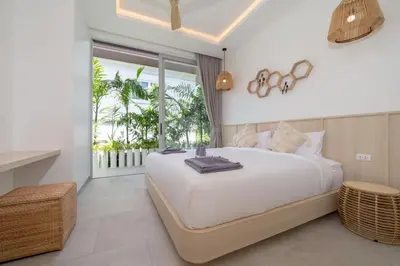 a bedroom with a large white bed and a balcony at Tropical Brand New 4BR Pool Villa Mina, just 5 min Drive from Naiharn in Rawai Beach