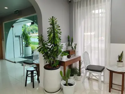 a room with potted plants and a table and chairs at Ratana Hotel Rassada, PHUKET TOWN- SHA Extra Plus in Phuket Town