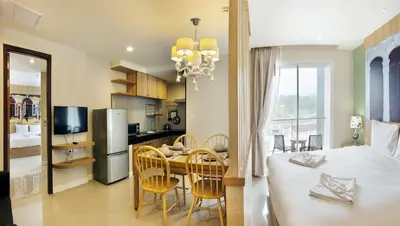 a kitchen and dining room with a table and chairs at Ratana Hotel Rassada, PHUKET TOWN- SHA Extra Plus in Phuket Town