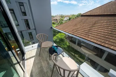 a balcony with two chairs and a roof at Tropics Kamala Corner Studio CTG D309, 3 Pools & Gym, near Beach in Kamala Beach