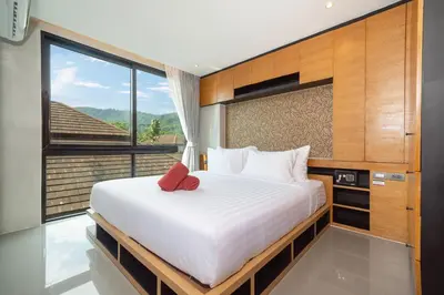 a bedroom with a large bed and a large window at Tropics Kamala Corner Studio CTG D309, 3 Pools & Gym, near Beach in Kamala Beach